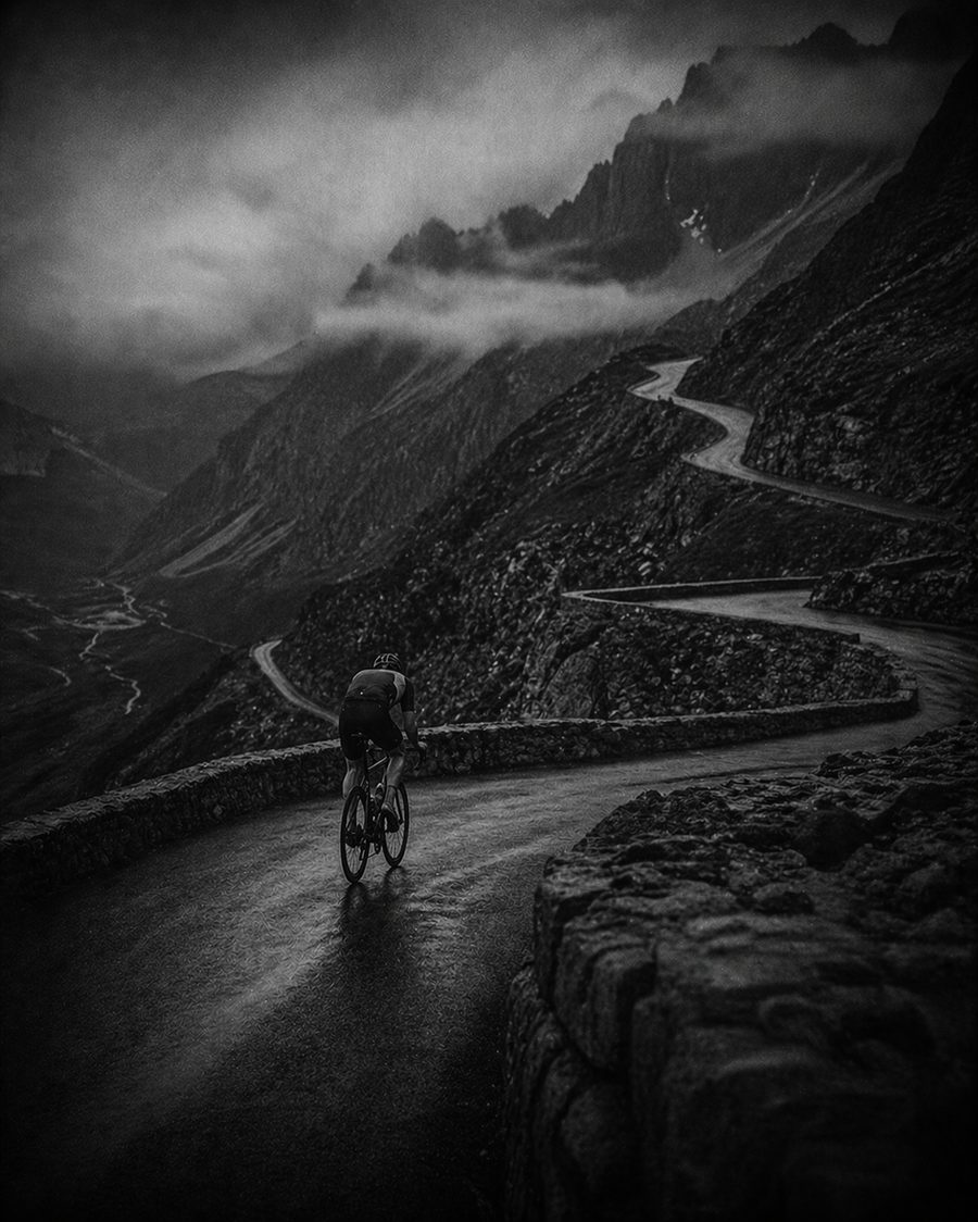 Cycliste gravissant un col alpin sous la brume — pilier Cyclisme FORTE
