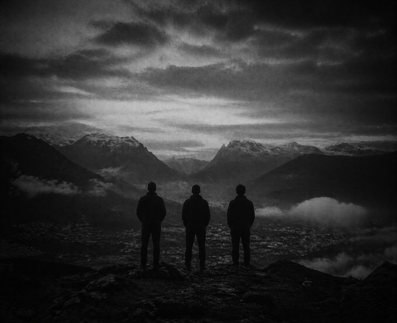 Trois silhouettes face à une vallée suisse au crépuscule — les co-fondateurs de FORTE